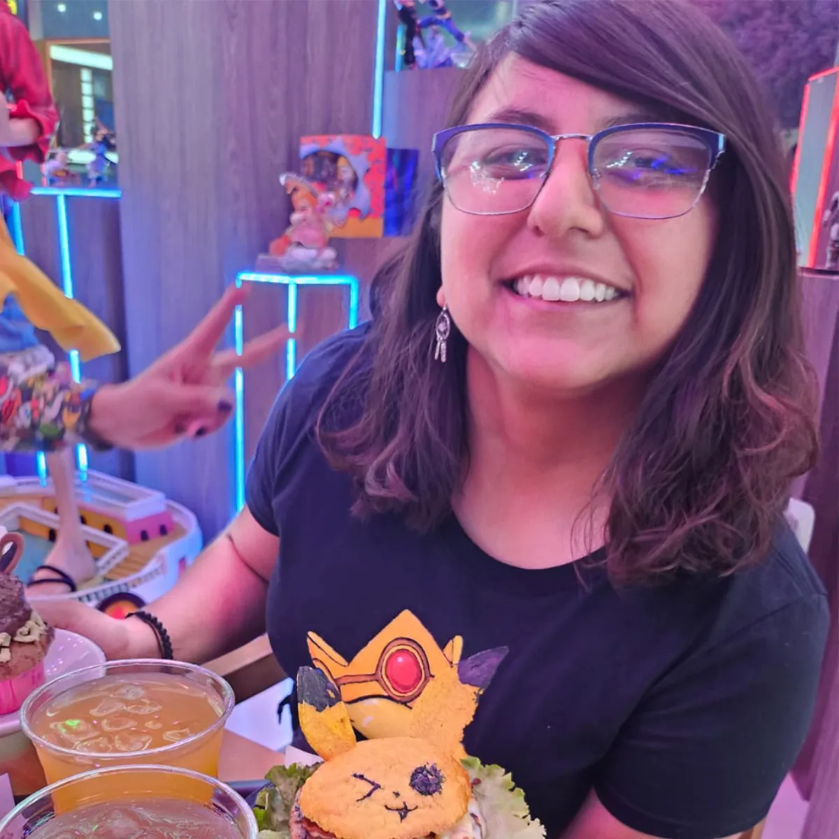 Retrato de Gangy sonriendo en un restaurante, rodeada de objetos coloridos y elementos creativos.