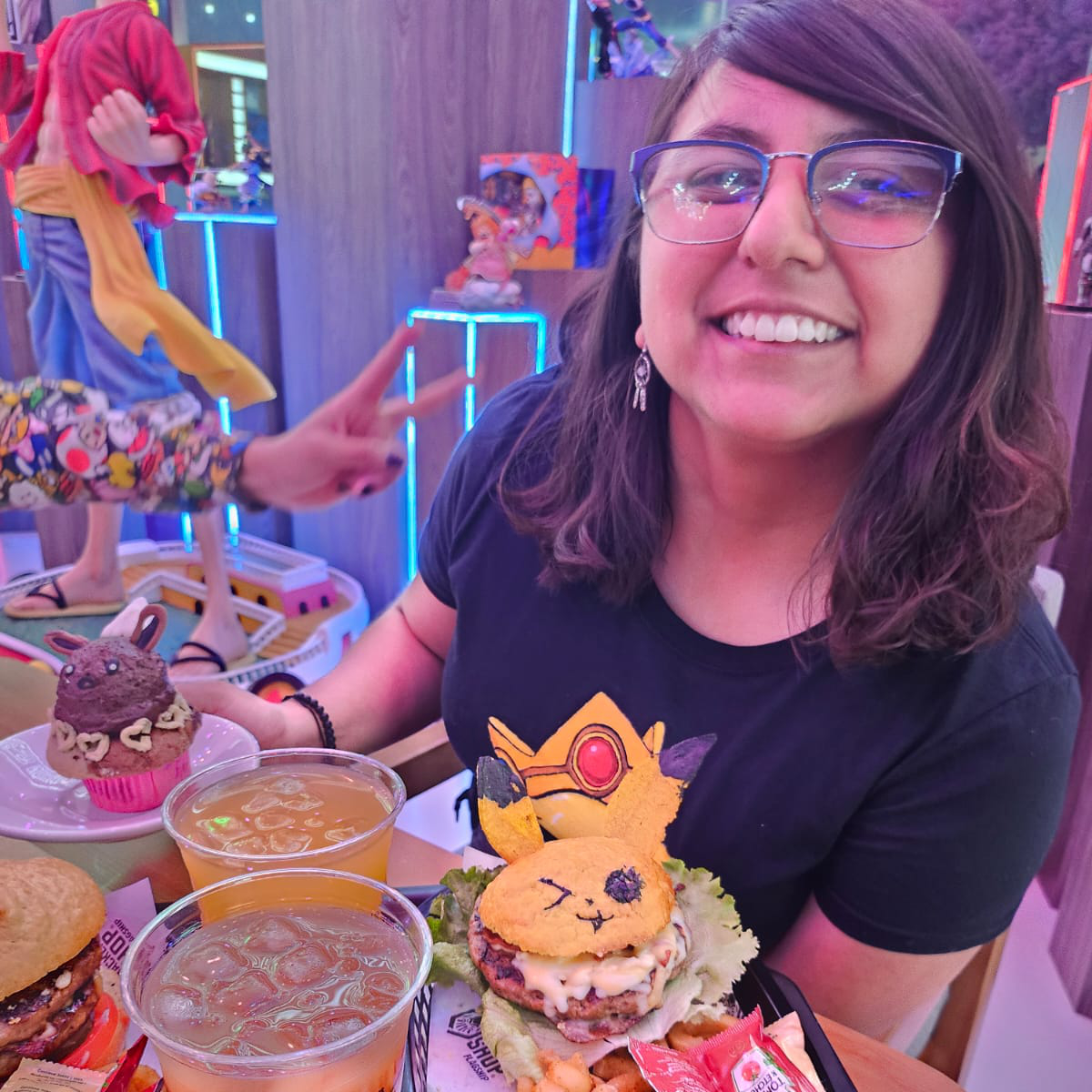 Retrato de Gangy sonriendo en un restaurante, rodeada de objetos coloridos y elementos creativos.